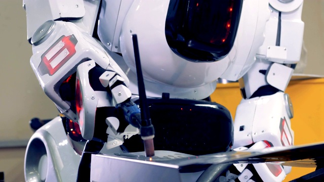 工业类人机器人与焊机工作，特写。视频下载