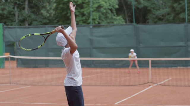 网球比赛中，运动员童子与选手击打球拍在球场上互相传球视频下载