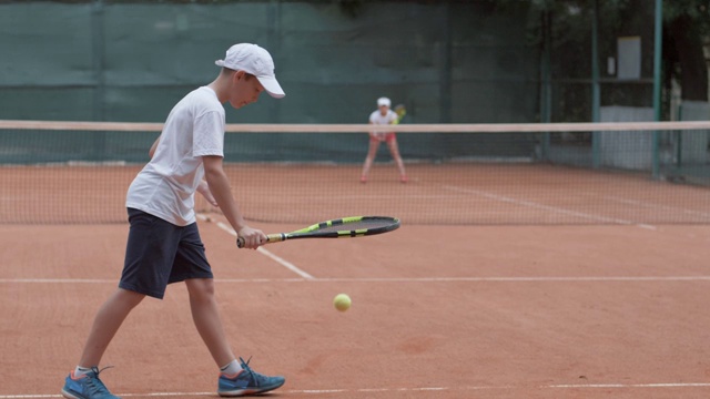 职业网球，体育运动员少年与对手击球拍在球场上传递给对方视频下载