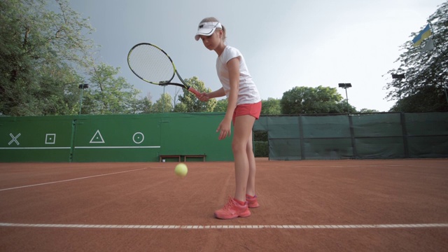 网球比赛，雄心勃勃的运动运动员青少年女孩在职业红色球场的比赛期间在露天拍球视频下载