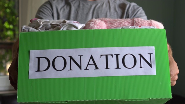一名男子将不需要的物品捐赠给慈善商店。志愿活动。慈善服装回收视频下载