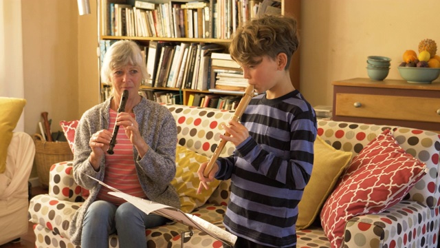 老奶奶教她的孙子吹竖笛视频素材