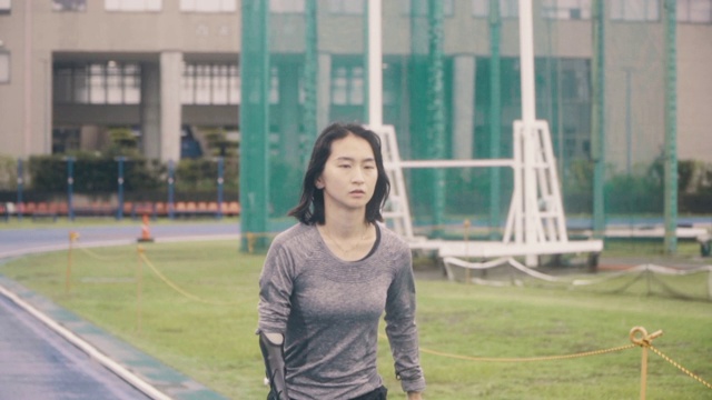 中等镜头的女性适应性运动员训练比赛在一个大学的田径体育场视频下载