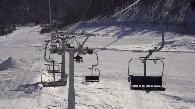 俄罗斯贝加尔湖，阳光灿烂的日子里，游客在空中滑雪缆车上视频下载