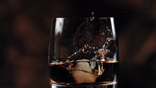 SLO MO:在威士忌中加入冰块视频素材