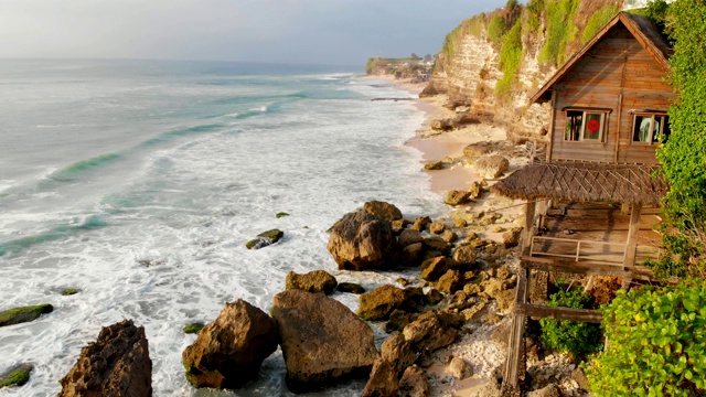 带有海浪的海岸线鸟瞰图。巴厘岛的海滩、老房子和海浪视频下载