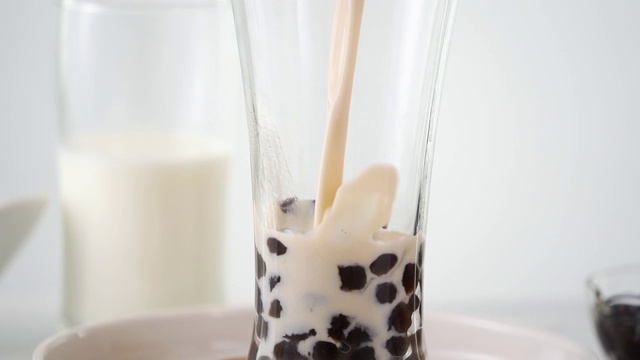将奶茶倒入饮用杯中，加入台湾流行的珍珠泡。视频素材