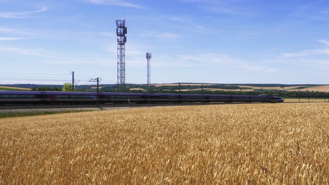 法国高速铁路TGV列车从土堆经过麦田和圆形稻草包，默兹区，洛林视频下载