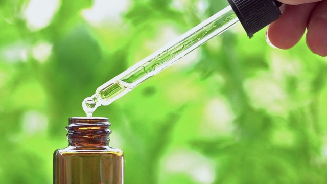 芳香疗法油滴在绿色的自然背景。视频下载
