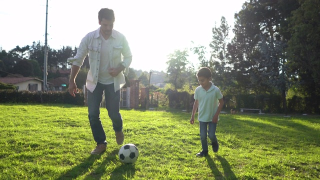 快乐的父子俩在后院踢足球视频素材
