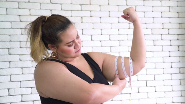 泰国超重妇女用卷尺测量她的手臂视频下载