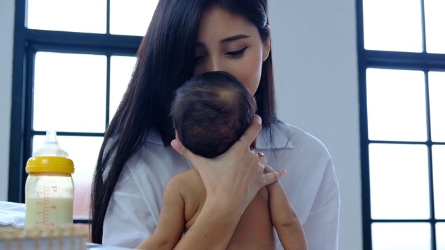 年轻的亚洲母亲抬起头，亲吻她刚出生的婴儿视频素材