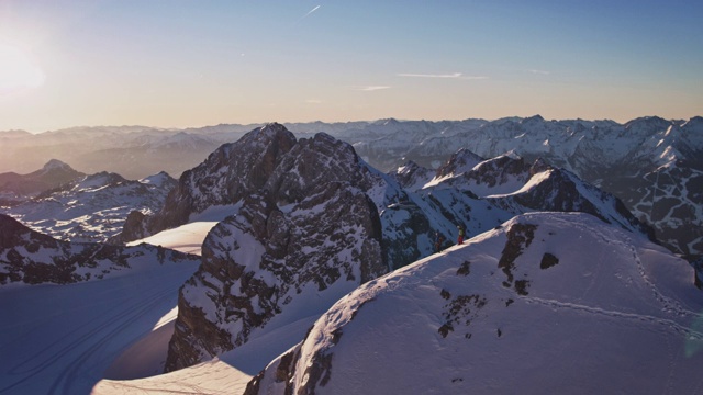 成年男性徒步旅行者在白雪覆盖的山脊上行走视频素材