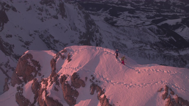 男性登山运动员在白雪覆盖的山脊上行走视频素材