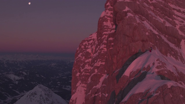 雄鸟在日出时站在积雪覆盖的山脊上视频素材