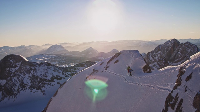 人们在阳光明媚的日子里走在白雪覆盖的山脊上视频素材