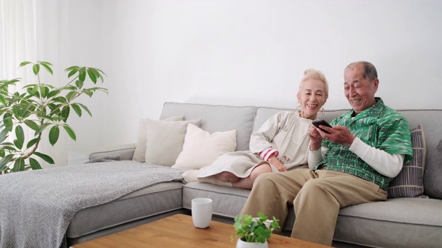 日本老年夫妇在智能手机上做观看选择视频素材