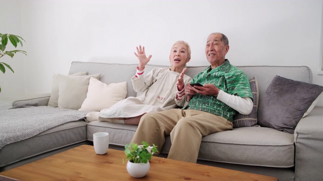 日本老年夫妇在智能手机上做观看选择视频素材