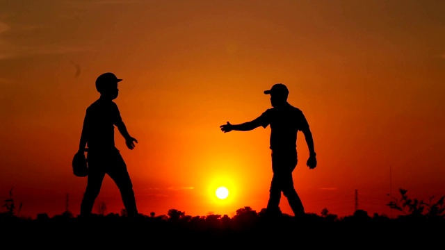 剪影棒球，两个男人一起练习扔棒球视频素材