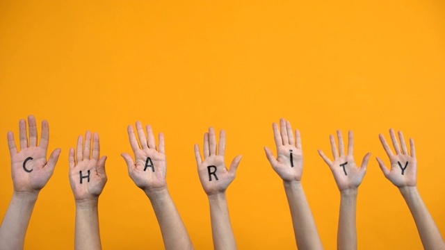 橙色背景的慈善手写手掌，捐赠中心，志愿者项目视频素材