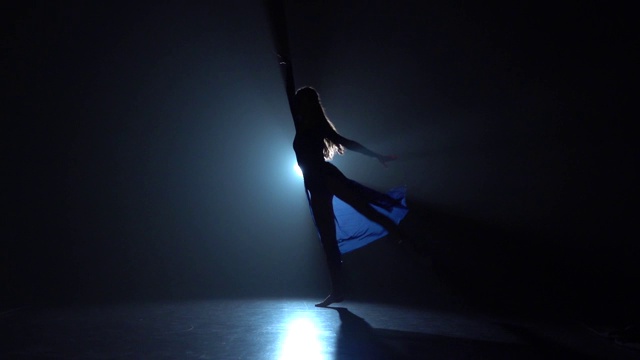 芭蕾舞者在工作室的聚光灯下跳着圈。慢动作视频下载