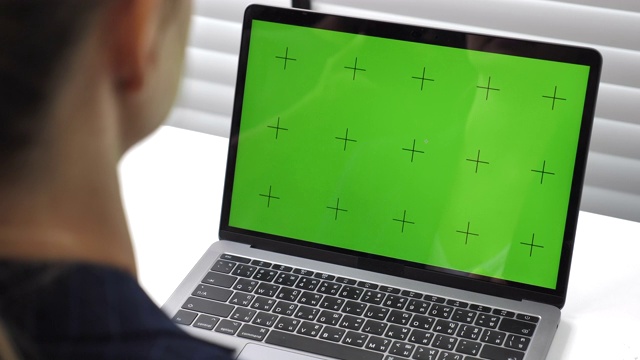 女商人在办公室里使用绿色屏幕的笔记本电脑视频下载