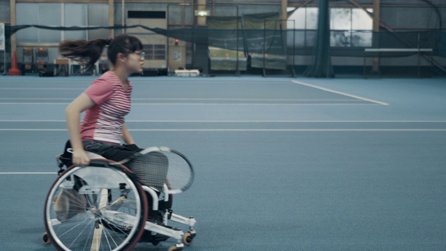 一个坐轮椅打网球的少女的广角镜头视频下载