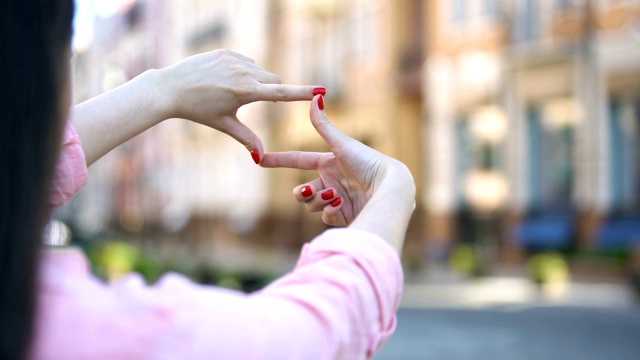 女人的手在街道上做框架手势的特写，摄影概念视频下载