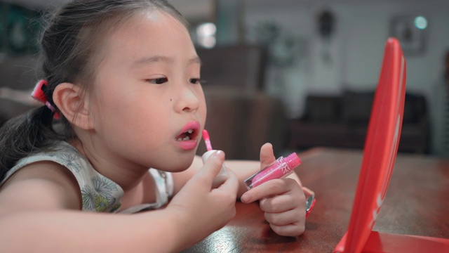 儿童亚洲女孩化妆她的脸视频素材