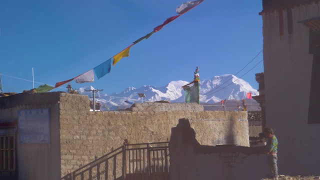 慢镜头:穿过西藏一个挂着经幡的村庄。视频素材
