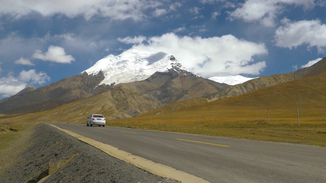 低角度白色汽车行驶在空旷的道路上，驶过雄伟的卡罗拉冰川视频素材