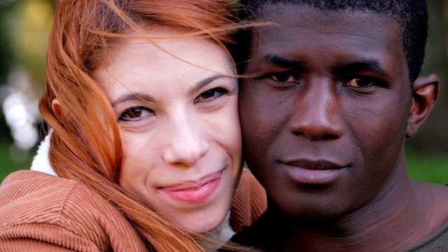 跨种族的爱:迷人的跨种族年轻夫妇看着镜头。视频下载