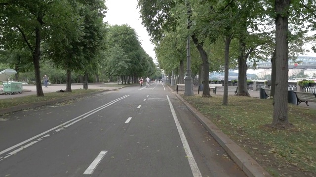 相机沿着城市公园的自行车道移动，在一个阴天。视频素材