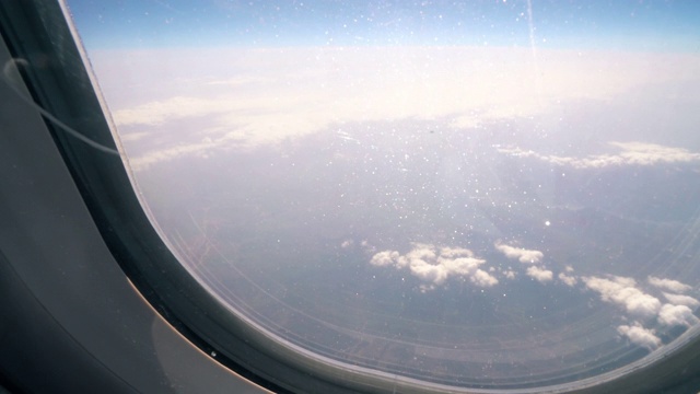 镜头靠近:男子打开飞机窗户，让眩目的光线进入机舱视频素材