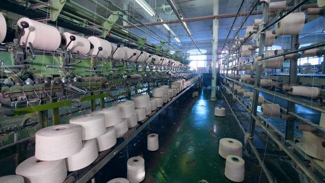 服装厂用白色纱线机械成型织物。纺织工厂设备。视频下载