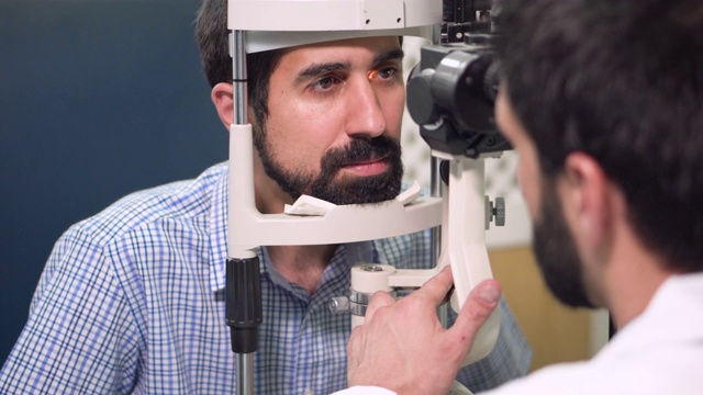 眼科医生检查年轻人视力-眼科诊所病人。视频下载