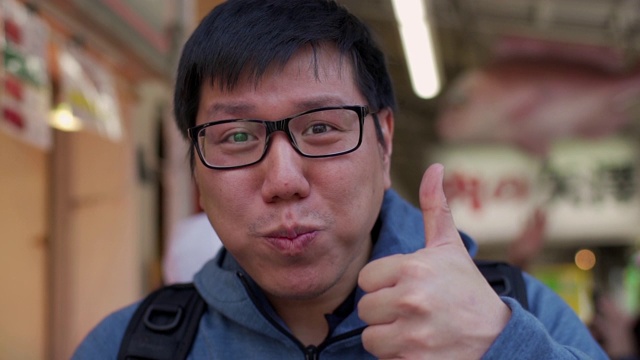 亚洲背包客游客在日本街头小吃市场吃金枪鱼寿司视频素材