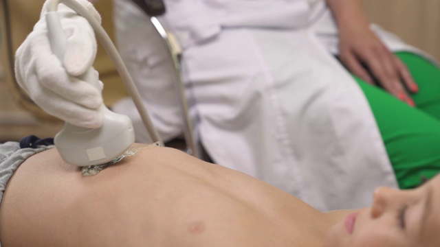 一个专业医生做超声波扫描小病人的腹部特写。医学的概念视频素材