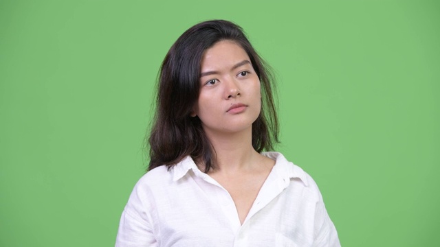 面对快乐年轻美丽的亚洲女人的思考视频素材