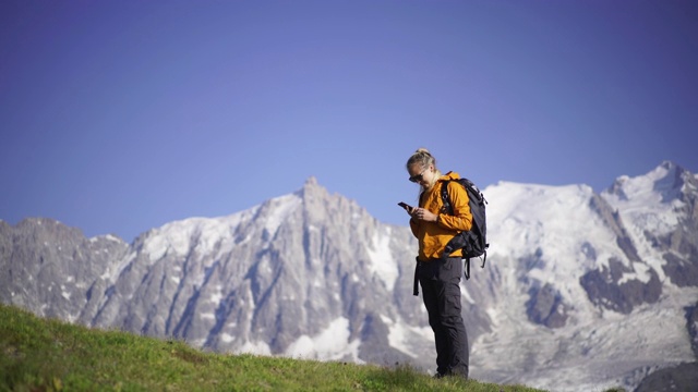 女徒步者在山顶用智能手机拍照视频下载