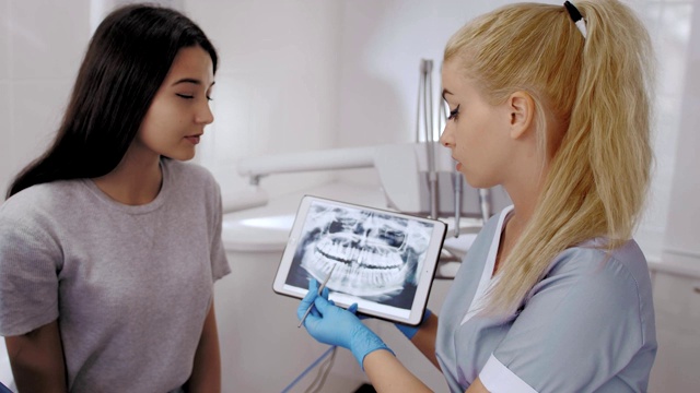 牙科医生和病人选择治疗咨询与医疗设备的背景视频素材