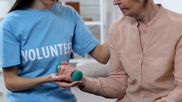 女性志愿者娱乐治疗师帮助年老的女士在疾病后恢复视频素材