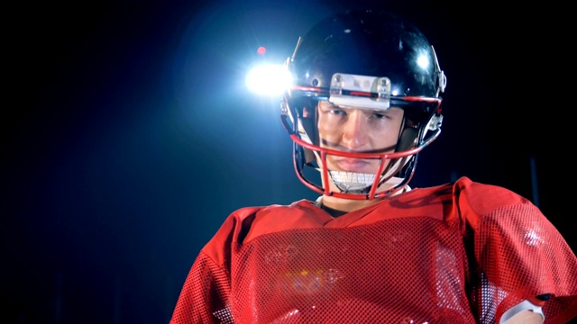 在美式橄榄球赛场上，足球运动员正戴着头盔视频素材