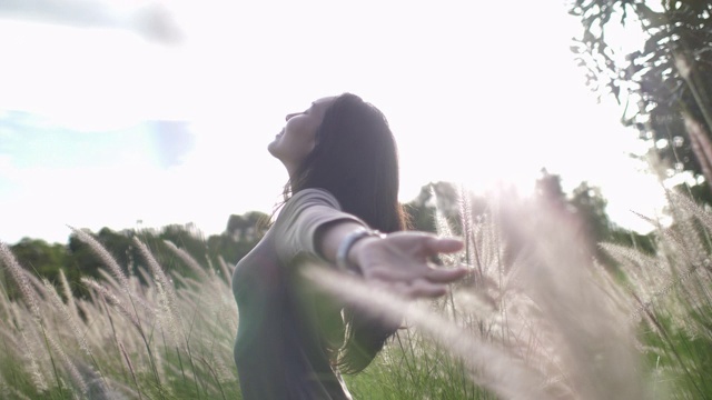 自由妇女在草地上举起手臂视频下载