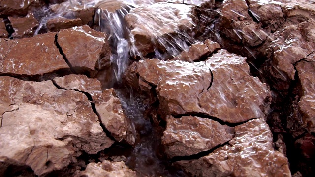 自然灾害的概念:流向地面的水是干裂的视频素材