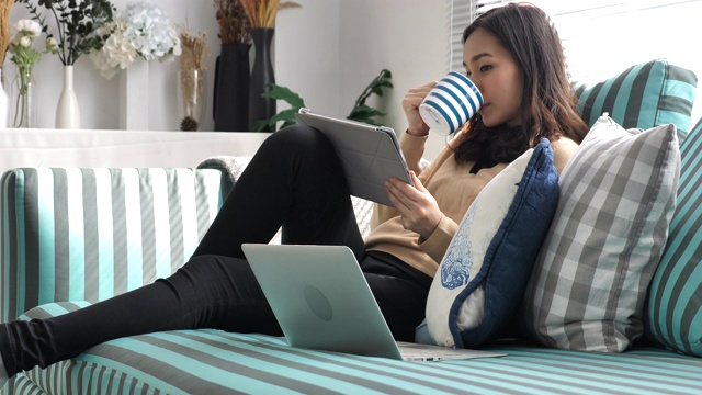 亚洲女性在家里使用数字平板电脑视频素材