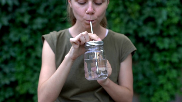女人用玻璃杯喝水，选用可重复使用的安全材料，生态视频下载