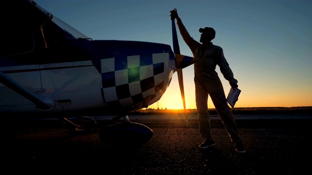 日落起飞跑道上，一名男维修工程师正在清理飞机视频下载