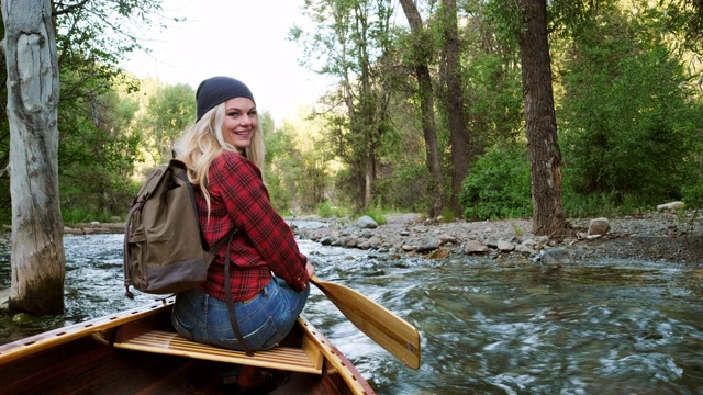 年轻的成年女子在荒野河上的独木舟上视频素材