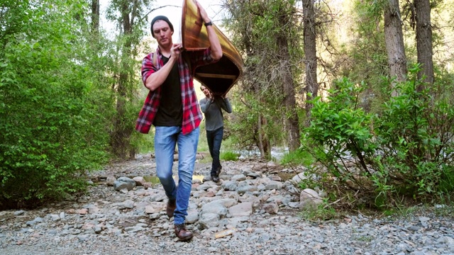 在荒野中划着独木舟的年轻人视频素材